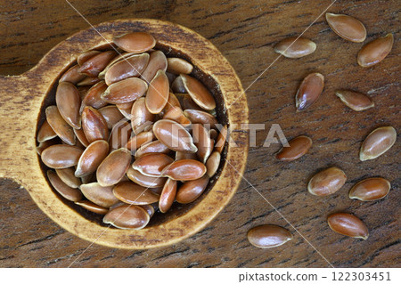 Flax seeds. Flaxseed powder in a wooden spoon. Standing on a Wooden  background. 122303451