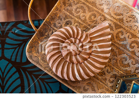 wooden snail on the table. mollusk shell figurine in the interior 122303523