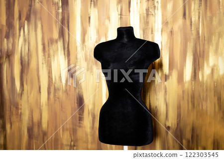 soft black mannequin against golden wall. female fitting room mannequin covered with black fabric soft black mannequin against golden wall. female fitting room mannequin covered with black fabric 122303545