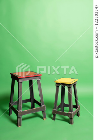 two wooden chairs on green paper background. furniture on color background 122303547