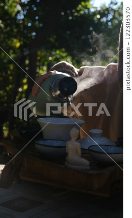 Experience the Elegant Art of Tea Pouring Under the Gentle Embrace of Natural Light 122303570