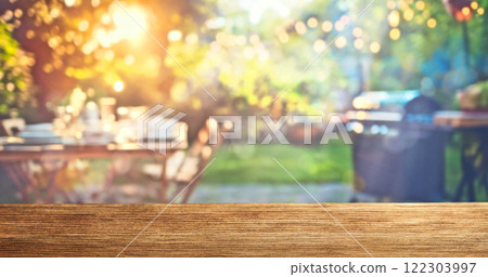 summer time party in backyard garden with grill BBQ, wooden table, blurred background 122303997