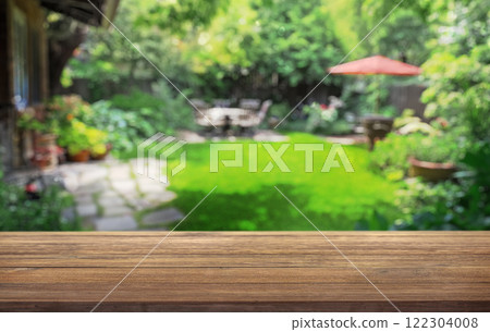 summer time party in backyard garden with grill BBQ, wooden table, blurred background 122304008