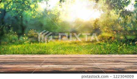 natural grass garden background with blurred bokeh and sun rays on wood board 122304009