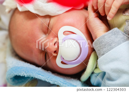 Closeup of little newborn sleeping with teat in mouth Closeup of little newborn sleeping with teat in mouth 122304303