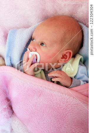 Newborn baby lying in bed with dummy Newborn baby lying in bed with dummy 122304304