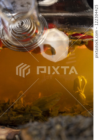 red rosehip fruits and hot green tea in a transparent teapot red rosehip fruits and hot green tea in a transparent teapot 122304425