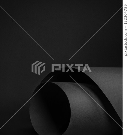 Black textured paper that comes rolled for various creative projects as backdrop or mockup 122304789