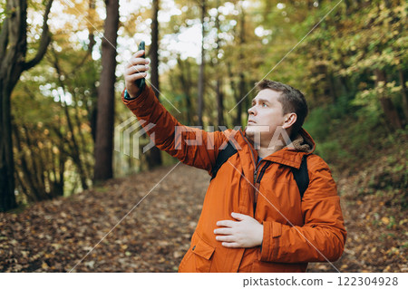 Sad angry blonde man got lost and could not find an internet connection on phone while hiking alone in the forest. Road trip, transport, travel, technology and people concept. High quality photo Sad angry blonde man got lost and could not find an internet connection on phone while hiking alone in the forest. Road trip, transport, travel, technology and people concept. High quality photo 122304928