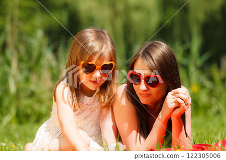 Mother and daughter having picnic in park 122305006