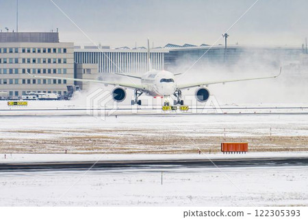 New Chitose Airport in winter: Snow smoke and taxiing airplanes, Chitose, Hokkaido 122305393