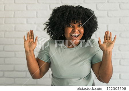 African American woman expressing pure joy with an enthusiastic and open expression. Excitement, energy and contagious sense of positivity African American woman expressing pure joy with an enthusiastic and open expression. Excitement, energy and contagious sense of positivity 122305506