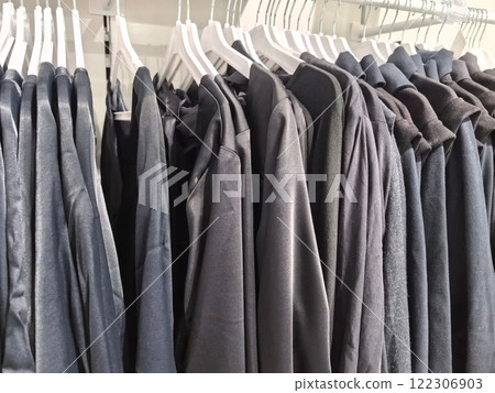 Stylish assortment of gray clothing hanging in a modern retail store Stylish assortment of gray clothing hanging in a modern retail store 122306903
