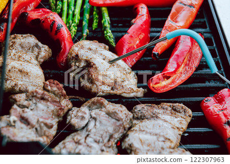 Cooking of meat and vegetables on a grill or on barbeque with temperature check. 122307963