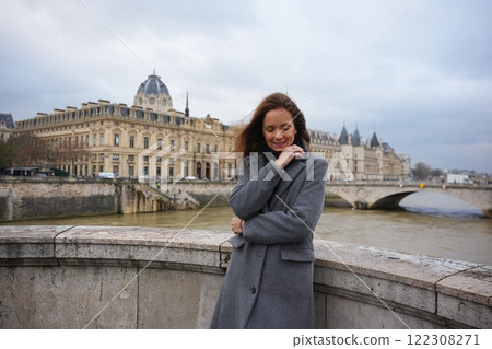 Woman Admiring Seine River and Paris Architecture on a Cloudy Day  122308271