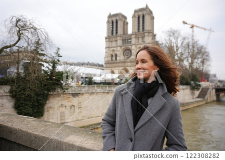 Smiling Woman Near Notre-Dame Cathedral, Paris, on a Breezy Winter Day Smiling Woman Near Notre-Dame Cathedral, Paris, on a Breezy Winter Day 122308282
