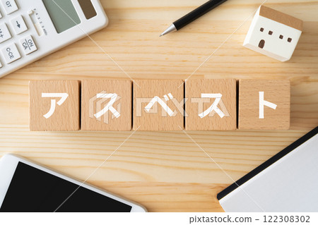 Blocks with asbestos written on them, a calculator, a smartphone, and a toy house Blocks with asbestos written on them, a calculator, a smartphone, and a toy house 122308302