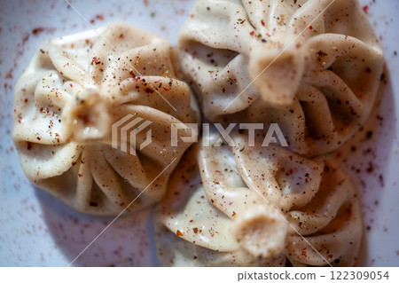 Khinkali dumplings dusted with spices on a plate shot in closeup detail showing texture Khinkali dumplings dusted with spices on a plate shot in closeup detail showing texture 122309054