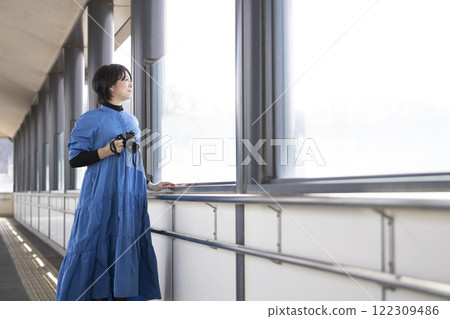 A woman holding a camera at a station 122309486