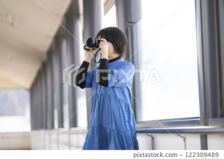 A woman holding a camera at a station 122309489