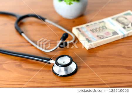 Image of medical expenses and insurance premiums with a stethoscope and a stack of bills 122310093