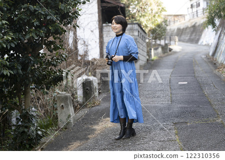 A woman holding a camera while traveling A woman holding a camera while traveling 122310356