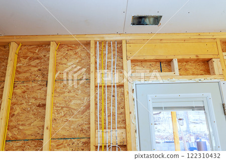 Installing wood framing, electrical wiring in residential construction project during installing drywall Installing wood framing, electrical wiring in residential construction project during installing drywall 122310432