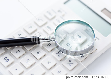 White calculator and magnifying glass 122310719