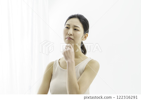 A young woman with a troubled face on a white background 122316291