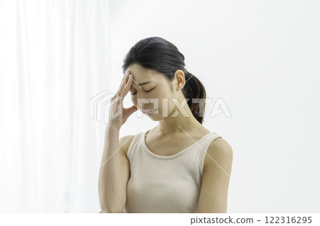 Young woman holding her forehead against white background, headache, illness 122316295