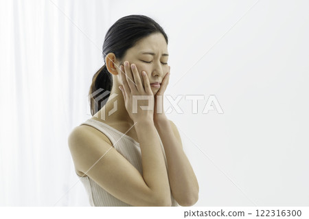 一位年輕女子,白色背景,臉色困擾,雙頰粗糙,皮膚粗糙 一位年輕女子,白色背景,臉色困擾,雙頰粗糙,皮膚粗糙 122316300