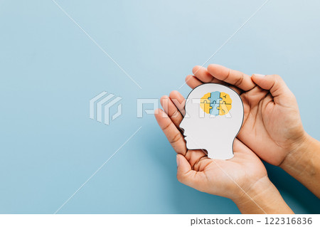 Down Syndrome Day celebrates awareness with hands holding a brain jigsaw in a head cutout. 122316836