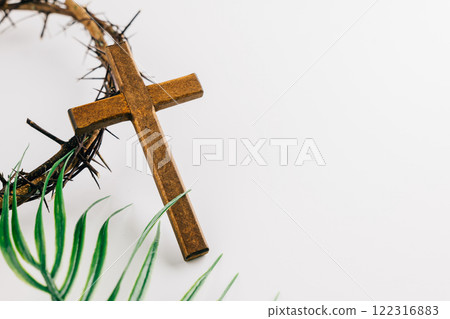 Wooden cross with crown of thorns and palm leaves on white for Palm Sunday. 122316883