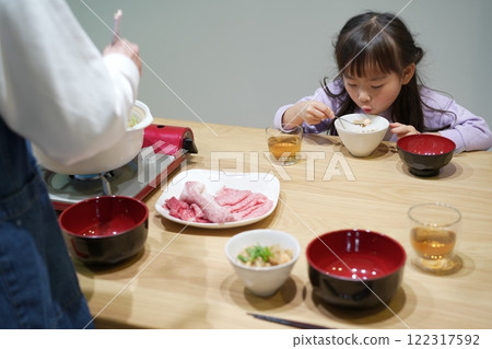 Family time: Smiling faces around sukiyaki at home Family time: Smiling faces around sukiyaki at home 122317592