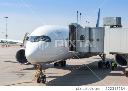 White wide body passenger airplane at the boarding bridge 122318284