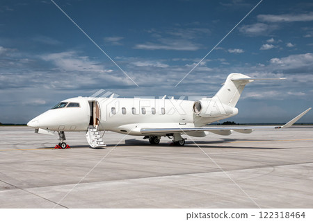 Modern white corporate business jet with a lowered gangway door at the airport apron 122318464