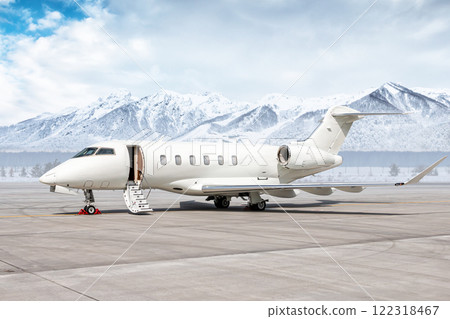 Modern white business jet with an opened gangway door at the winter airport apron on the background of high picturesque snow capped mountains Modern white business jet with an opened gangway door at the winter airport apron on the background of high picturesque snow capped mountains 122318467