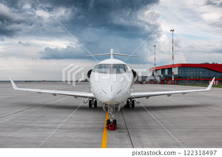 Modern white corporate airplane on the airport apron on a cloudy day Modern white corporate airplane on the airport apron on a cloudy day 122318497