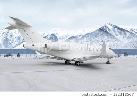 Modern white private jet at the airport apron on the background of high scenic snow capped mountains 122318507