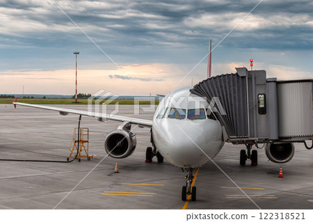 Modern passenger aircraft at the aerobridge in the evening 122318521