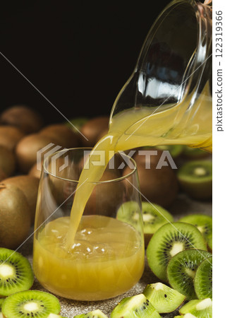 Kiwi juice pour into a glass from a jug 122319366