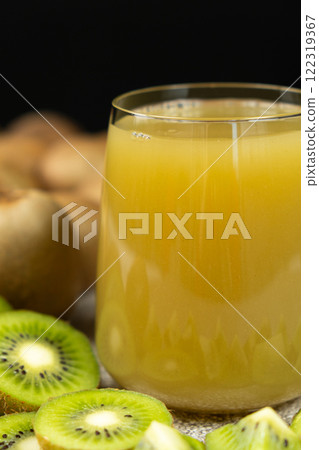 Kiwi juice in a glass among fresh kiwi fruits. 122319367
