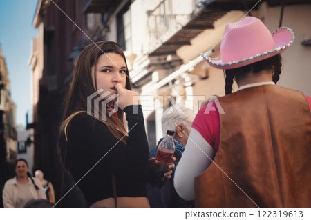 Young woman in contemplation on a bustling city street, colourful characters and urban environment in the background. 122319613