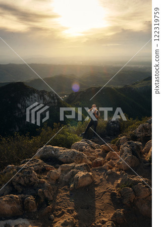 Woman with a backpack on her back on top of a mountain 122319759