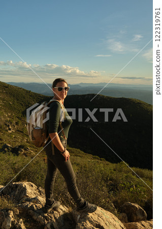 Woman with a backpack on her back on top of a mountain 122319761