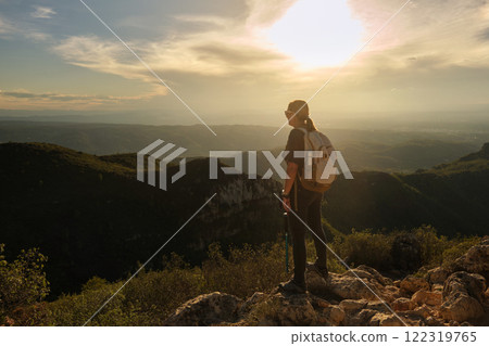 Woman with a backpack on her back on top of a mountain 122319765