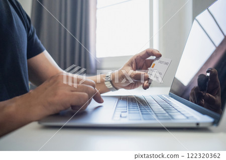 Man holding credit card while using laptop, shopping online, buying on internet. e-commerce e-banking service. Man holding credit card while using laptop, shopping online, buying on internet. e-commerce e-banking service. 122320362