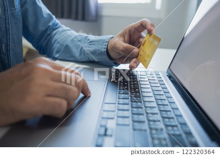 Man holding credit card while using laptop, shopping online, buying on internet. e-commerce e-banking service. 122320364