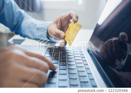 Man holding credit card while using laptop, shopping online, buying on internet. e-commerce e-banking service. 122320366
