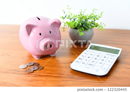 Image of a piggy bank and a calculator on a desk Image of a piggy bank and a calculator on a desk 122320445